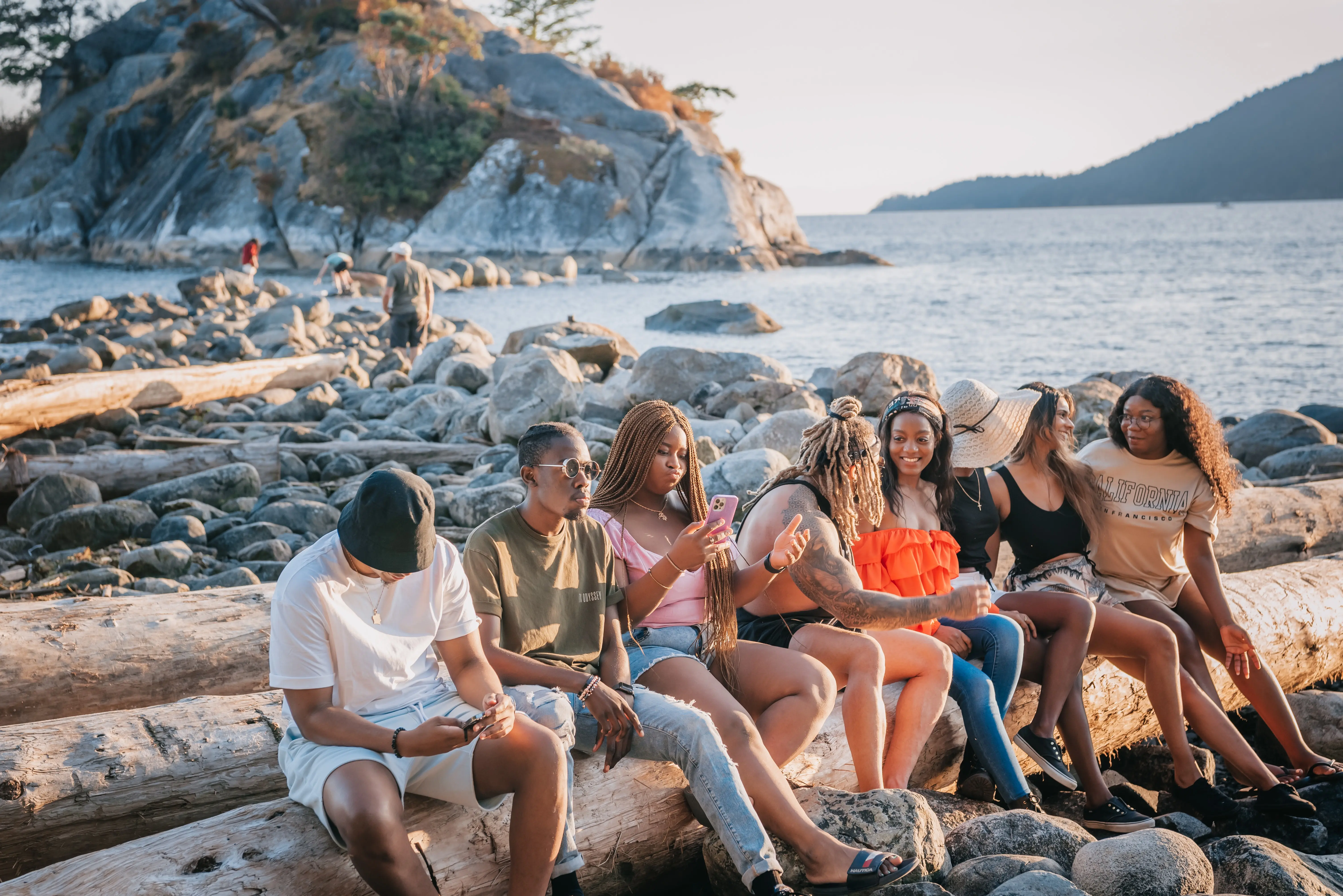 a group of foreigners sitting at the beach