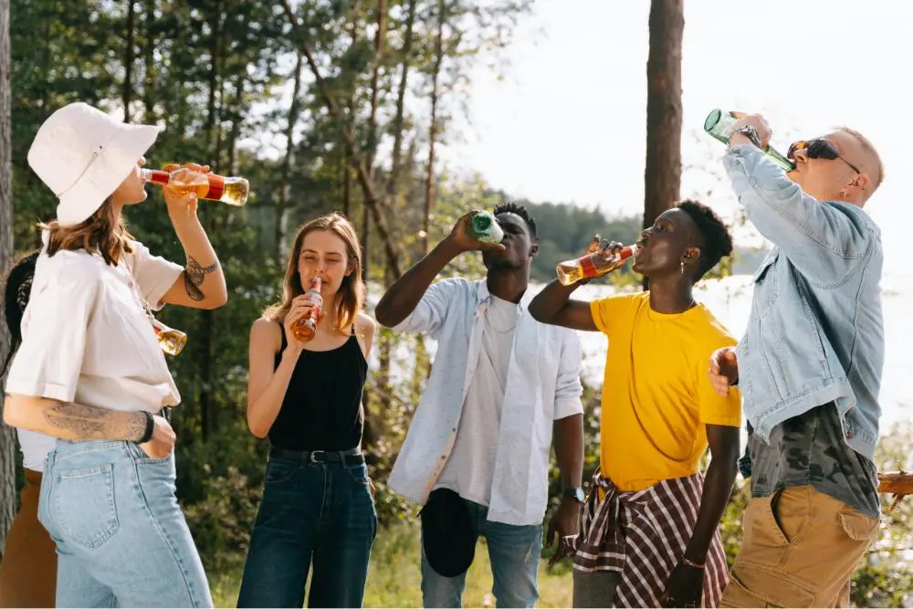 a group of five foreigners sipping drinks at the beach