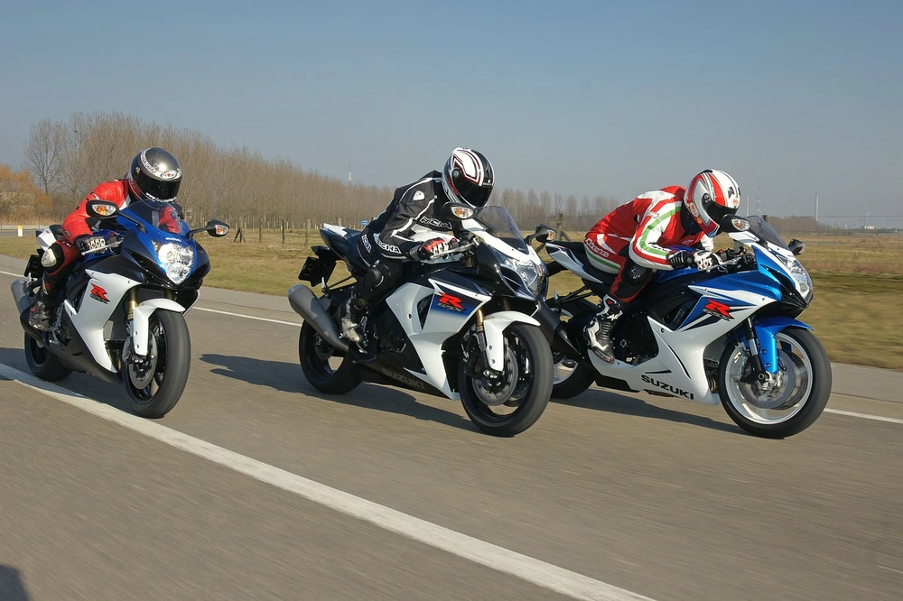 three motorcycle riders racing