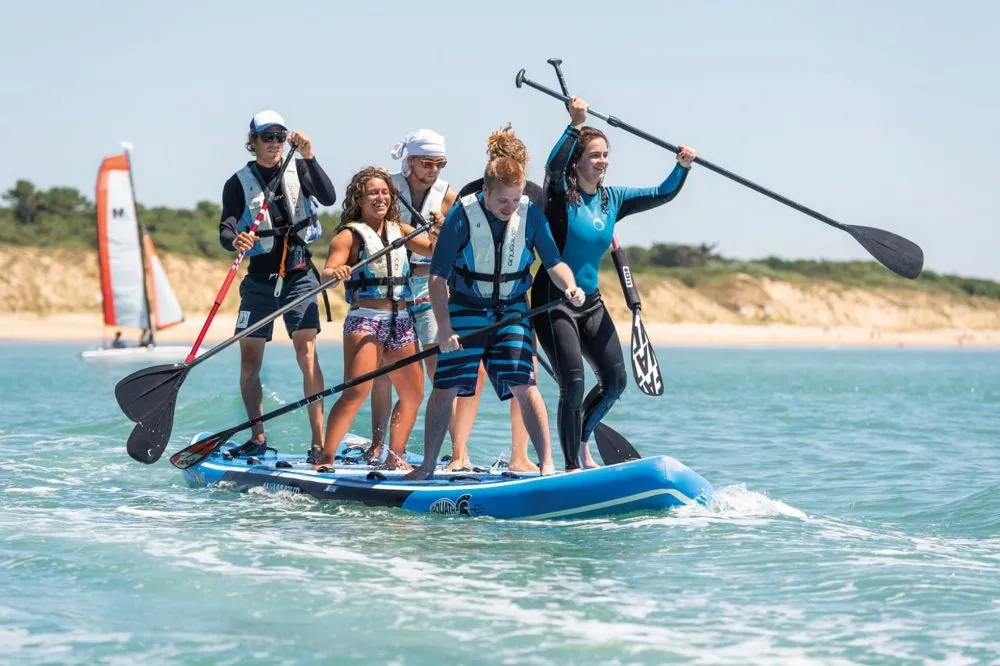 a group of foreiners surfing on the sea