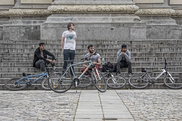 four young men relaxing with thier bicycles